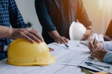 İnşaat mühendisi mühendisi. İş yerindeki mühendislik objeleri ile partnerler arka planda etkileşime giriyor. Mimari proje için mühendis toplantısı resmi.