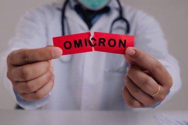 New generation vaccine against Coronavirus South African variant. Omicron variant of SARS-CoV-2. New B.1.1.529 Variant of concern. Doctor with a stethoscope Tear the red paper with the word Omicron. clipart