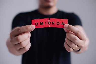 Steteskoplu adam kırmızı kağıdı Omicron sözcüğüyle yırt. Güney Afrika 'daki Coronavirus virüsüne karşı yeni nesil aşı. SARS-CoV-2 'nin Omicron versiyonu. Yeni B.1.529 Kaygılanma Varyantı