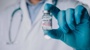 SARS-CoV-2 'nin Omicron versiyonu. Yeni B.1.529 endişe çeşidi. Doktorun elinde yeni covid-19 omikron varyantına karşı aşı var. Yeni nesil aşıya karşı