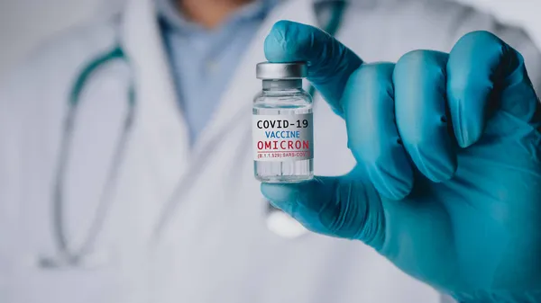 SARS-CoV-2 'nin Omicron versiyonu. Yeni B.1.529 endişe çeşidi. Doktorun elinde yeni covid-19 omikron varyantına karşı aşı var. Yeni nesil aşıya karşı