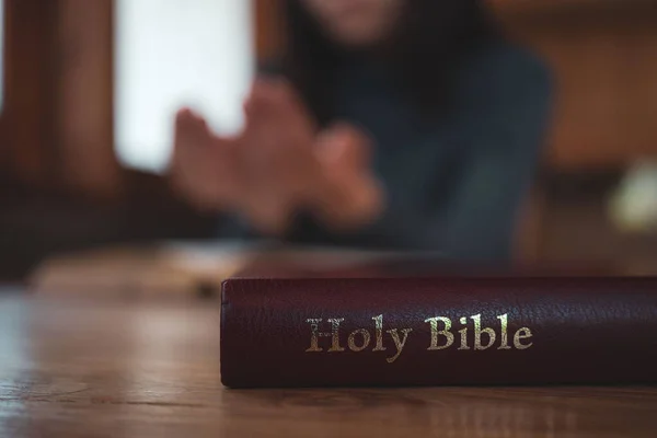 特写镜头下的基督教妇女阅读圣经 双手交叉在木制桌子上的圣经上祈祷 — 图库照片