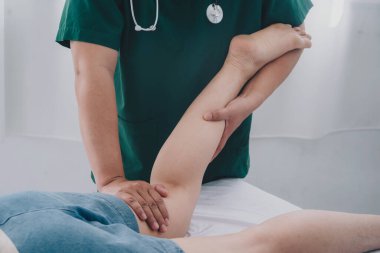Fiziksel rehabilitasyon kavramı yüzünden uzun süre oturmaktan dolayı uyluk ağrısını tedavi ediyor. Modern kliniklerde yaralı kalça ağrısını tedavi eden bir terapist..