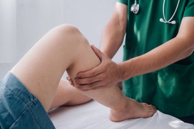 Fiziksel rehabilitasyon kavramı yüzünden uzun süre oturmaktan dolayı uyluk ağrısını tedavi ediyor. Modern kliniklerde yaralı kalça ağrısını tedavi eden bir terapist..