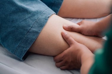 Fiziksel rehabilitasyon kavramı yüzünden uzun süre oturmaktan dolayı uyluk ağrısını tedavi ediyor. Modern kliniklerde yaralı kalça ağrısını tedavi eden bir terapist..