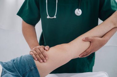 Fiziksel rehabilitasyon kavramı yüzünden uzun süre oturmaktan dolayı uyluk ağrısını tedavi ediyor. Modern kliniklerde yaralı kalça ağrısını tedavi eden bir terapist..