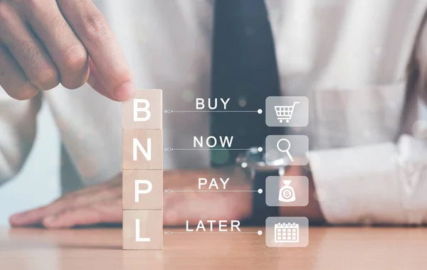 İşadamı elle ahşap bloğu çevrimiçi alışveriş simgeleriyle BNPL ile düzenliyor. Daha sonra online alışveriş konseptini satın al.
