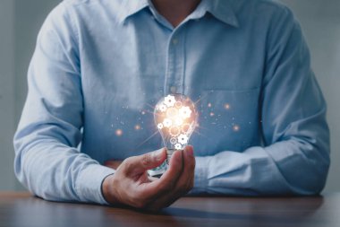 İş adamlarının elinde ampul simgesi ve insan gelişiminde sonsuz enerji vardır. Başarı kavramı