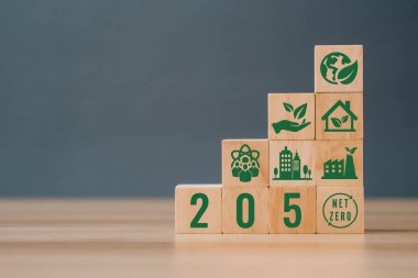 Gri arkaplanda 2050 'de sıfır ikonlu tahta küpler. 2050 'ye kadar net sıfır. Karbon nötr. Net sıfır sera gazı emisyon hedefi. İklim tarafsız uzun vadeli stratejisi.