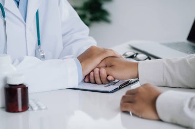 Doctor is holding the patient's hand and giving hope about treating the symptoms of the disease. PTSD Mental health concept