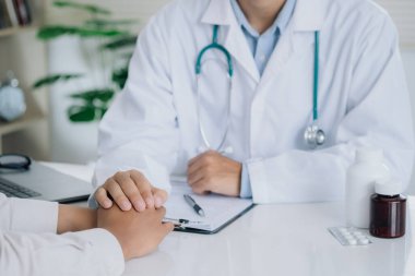 Doctor is holding the patient's hand and giving hope about treating the symptoms of the disease. PTSD Mental health concept