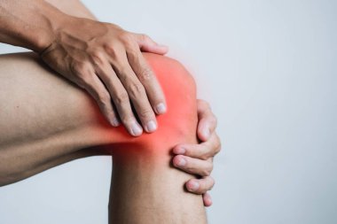 Ofis sendromu konsepti. Sağlık konsepti. Diz ağrısı çeken genç bir adam. metin için boşluk kopyala