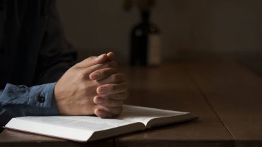 Sabahları kutsal İncil 'e dua eden adamın sarı ışıkları ve ışıltısı geliyor. İncil okuyan kadın eli. Hristiyan hayatı kriz duası.