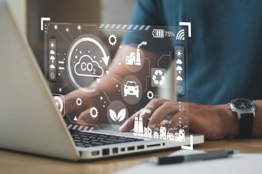 İş adamı küresel ısınma ikonu ile CO2 emisyon azaltma kavramında bilgisayar kullanıyor. İklim, enerji, sürdürülebilirlik ve çevreyle birlikte