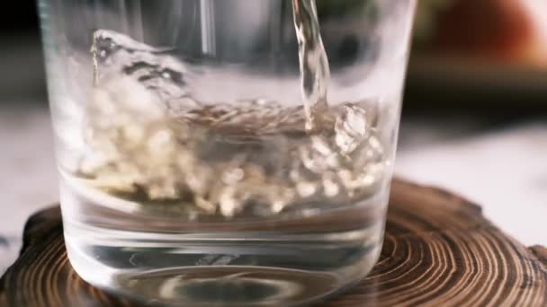 Pouring brandy or whiskey into a glass from above over a dark background — Stock Video