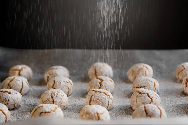 Amaretti - traditionelle italienische Mandelkekse in Zuckerpulver auf Backpapier. — Stockfoto