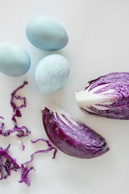 Boyalı mavi Paskalya yumurtaları beyaz arka planda doğal boya kırmızısı lahanayla boyanmış..