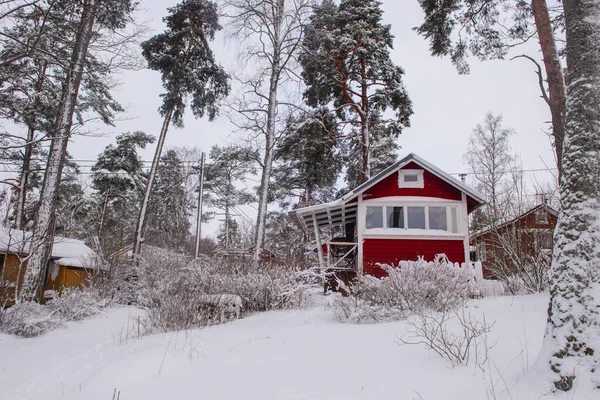 Casa finlandese in legno rosso in inverno coperta di neve. — Foto Stock