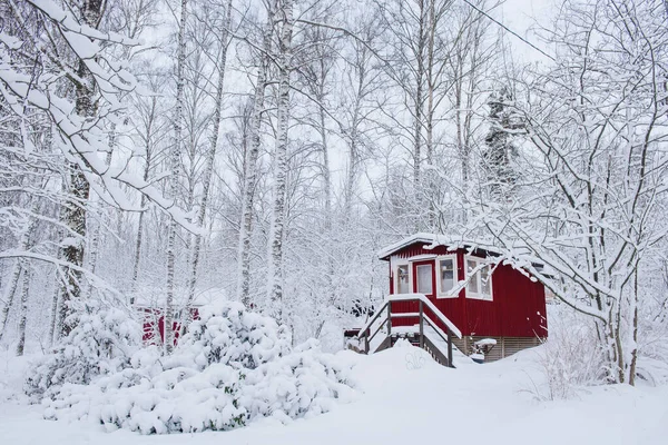 Czerwony drewniany fiński dom zimą pokryty śniegiem. — Zdjęcie stockowe