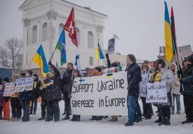 Protestocuların elinde Rus saldırısına karşı yapılan gösterilere ait posterler var. Helsinki, Finlandiya, 7.02.2022