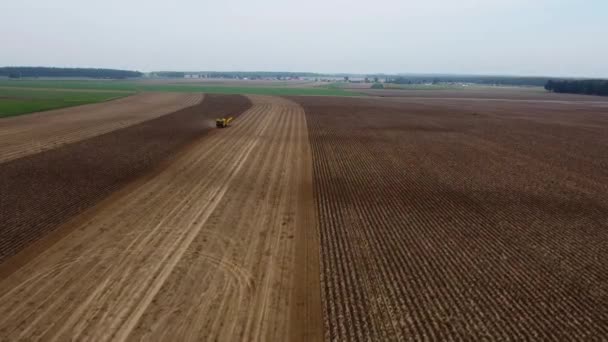 Tracteur et moissonneuse sur un champ agricole en Pologne. Un drone. Vue aérienne, vue de dessus. Cinématique. — Video