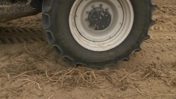 Primer plano de una rueda tractora que atraviesa el suelo. Recolección de patatas. Preparación del suelo. 4K cámara lenta. — Vídeo de stock