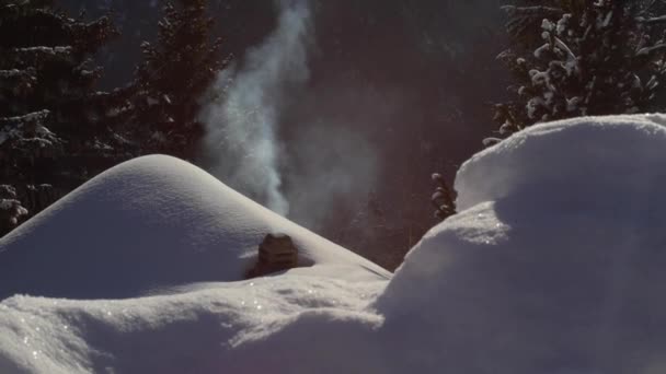 Moody tiro de uma chaminé com fumaça subindo. Chalé com neve no telhado. Inverno. — Vídeo de Stock