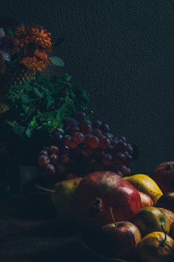 Karanlık barok rönesans tarzı. Meyve ve çiçeklerin hayat fotoğrafı. Elma, üzüm, nar, ayva, nane ve bahçe çiçekleri..