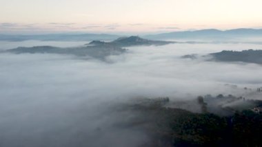 İHA atışı, Umbria 'nın havadan görüntüsü, İtalya' da Toskana. Sabahın erken saatlerinde sisli gün doğumu. Vadideki bulutlar.