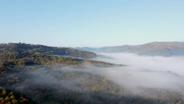 Strzał drona, widok z lotu ptaka z Umbrii, Toskania we Włoszech. Wschód słońca z mgłą wczesnym rankiem. Chmury w dolinie. — Wideo stockowe