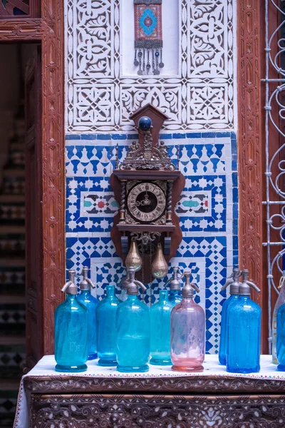 Εσωτερικό κοντινό πλάνο σε ένα Ριάντ στο Μαρακές του Μαρόκου με ένα ρολόι, μπλε πλακάκια και μπλε μπουκάλια ψεκασμού. — Φωτογραφία Αρχείου