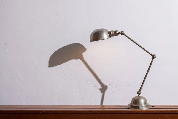 Vintage design Jielde lamp on a cabinet against a white wall. Copy space. — Foto de Stock