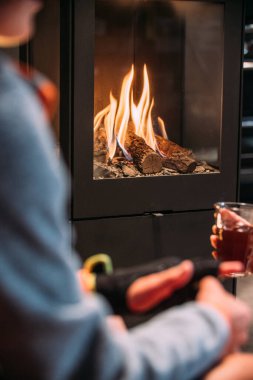 Genç çocuk şöminenin önünde..