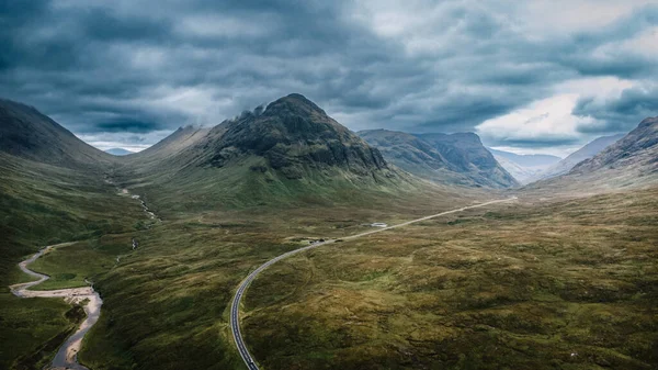 Panoramic landscape with mountains in Scotland. Drone shot. Winding road. High quality photo