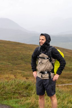 İskoçya dağlarında bir yürüyüşçü. Yağmurluk giyiyor. Yüksek kalite fotoğraf
