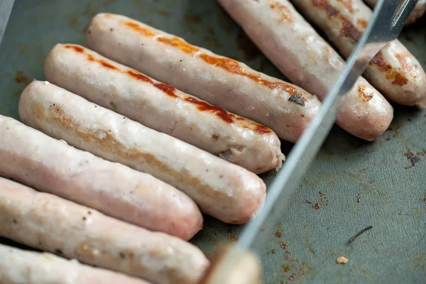 Sausages cooking in pan. Outdoor grilling. High quality photo