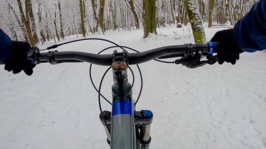 Amatör dayanıklı bisikletçi kış sezonunda bisiklet sürüyor.