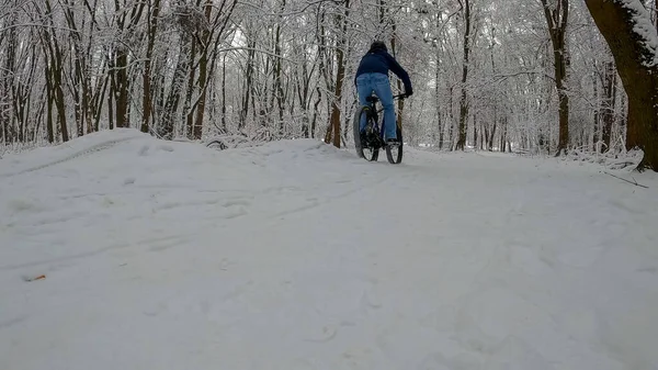Amatör dayanıklı bisikletçi kış sezonunda bisiklet sürüyor.