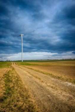 Mavi gökyüzü ve turbo jeneratörle elektrik rüzgar türbini üretiliyor.