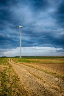 Mavi gökyüzü ve turbo jeneratörle elektrik rüzgar türbini üretiliyor.