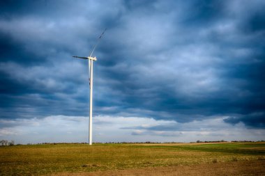Mavi gökyüzü ve turbo jeneratörle elektrik rüzgar türbini üretiliyor.