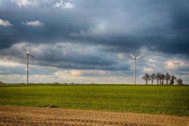 Mavi gökyüzü ve turbo jeneratörle elektrik rüzgar türbini üretiliyor.