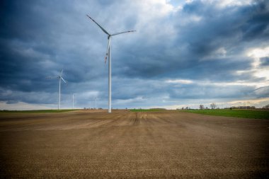 Mavi gökyüzü ve turbo jeneratörle elektrik rüzgar türbini üretiliyor.