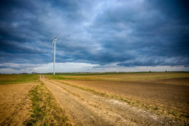 Mavi gökyüzü ve turbo jeneratörle elektrik rüzgar türbini üretiliyor.