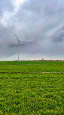 Mavi gökyüzü ve turbo jeneratörle elektrik rüzgar türbini üretiliyor.