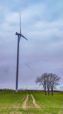 Mavi gökyüzü ve turbo jeneratörle elektrik rüzgar türbini üretiliyor.