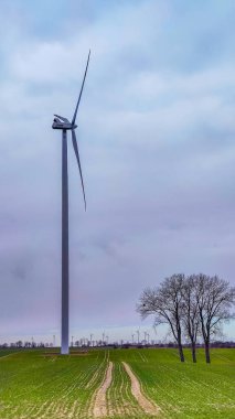 Mavi gökyüzü ve turbo jeneratörle elektrik rüzgar türbini üretiliyor.