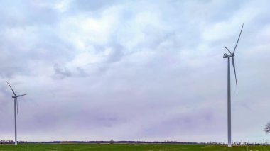 Mavi gökyüzü ve turbo jeneratörle elektrik rüzgar türbini üretiliyor.