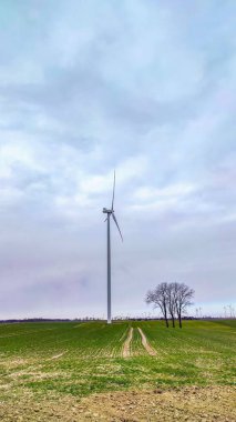 Mavi gökyüzü ve turbo jeneratörle elektrik rüzgar türbini üretiliyor.