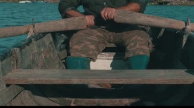 Yaşlı balıkçı geleneksel bir Tuna balığıyla kürek çekiyor..